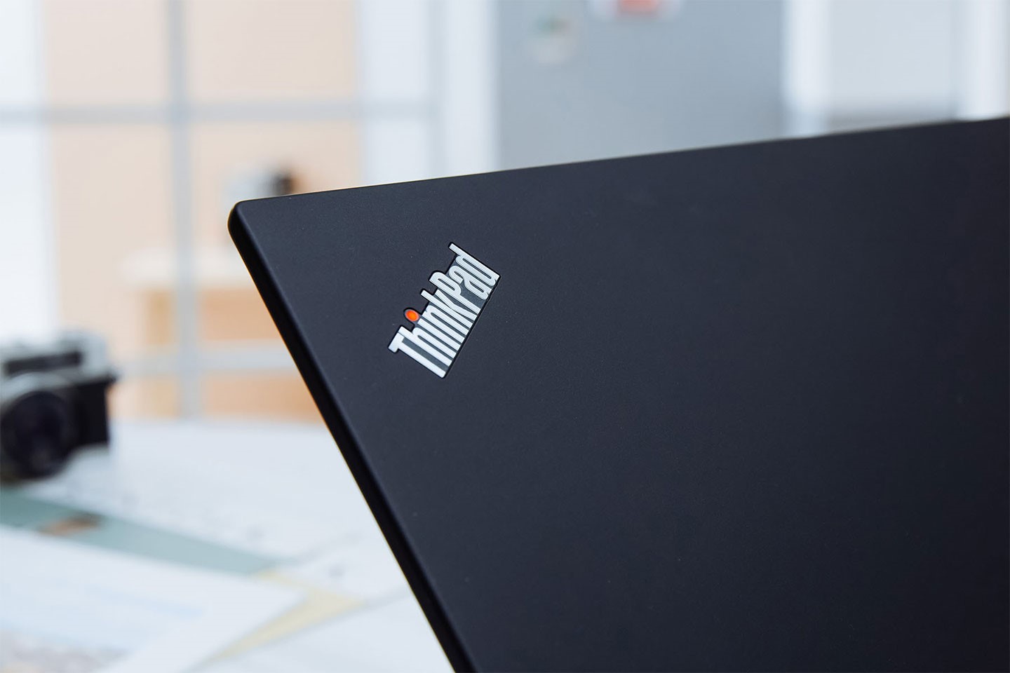 機身上蓋左上角有一枚 ThinkPad 金屬 Logo，開機時字母 i 頂端的小紅點會亮起紅色燈號。