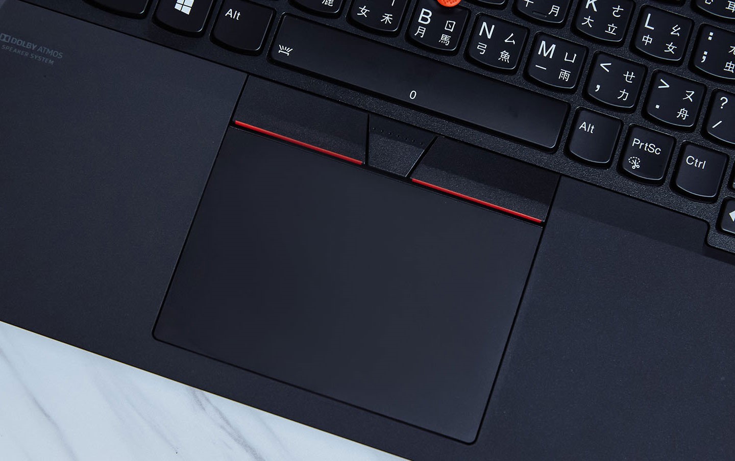由於 TrackPoint 小紅點必須配合左、右鍵一起操作，因此左、右鍵設計在觸控板上方。