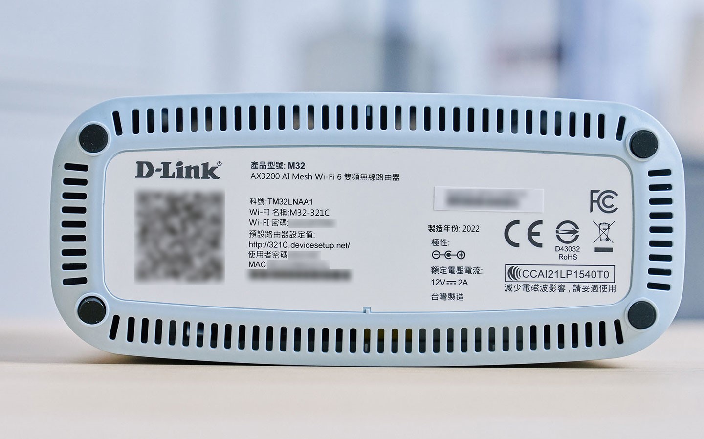 機身底部外圈同樣設置了一圈散熱孔,中央則列出安裝用的 QRCode、機器預設的 SSID、密碼與登入管理後台的網址…等資訊。