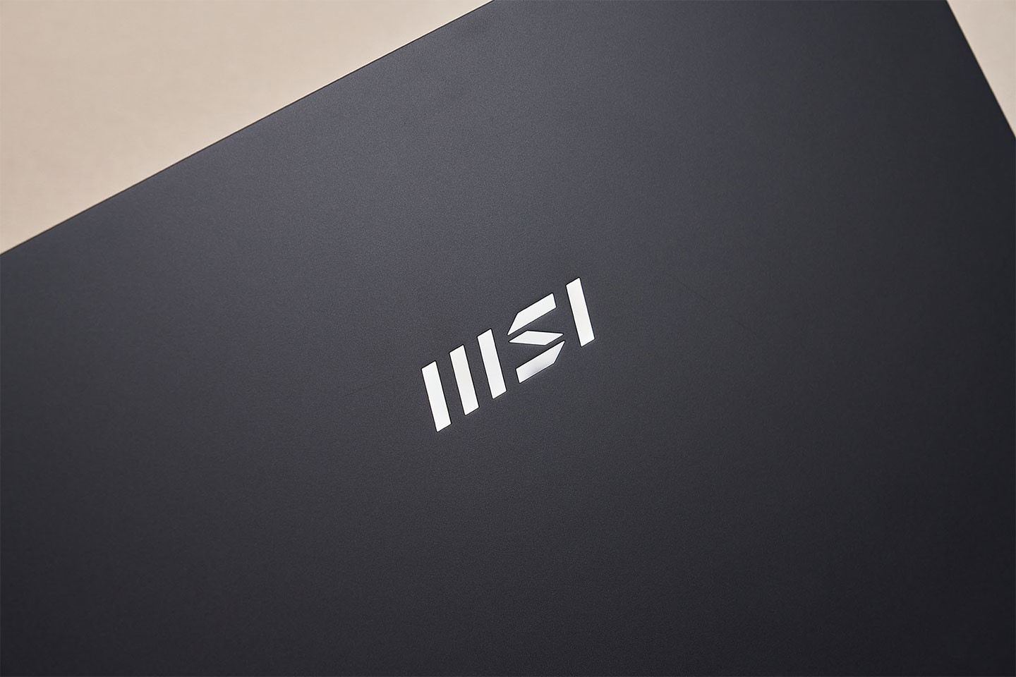 上蓋處規劃了一枚 MSI 新式企別 Logo，金屬亮面風格與霧面深色的上蓋形成強烈的對比。