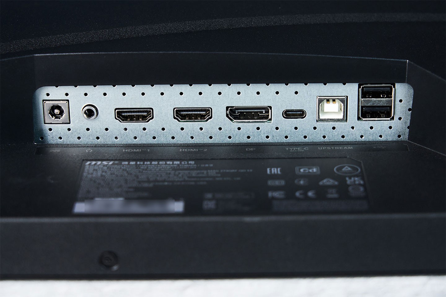 連結埠位於機背底側，由左至右分別為電源接口、3.5 mm 音源孔、HDMI 2.0b 兩組、一組 DP 1.4a、一組支援 PD 65W 供電的 USB Type-C，連結電腦端的 USB Type B 與兩組可擴充使用的 USB Type-A 埠。