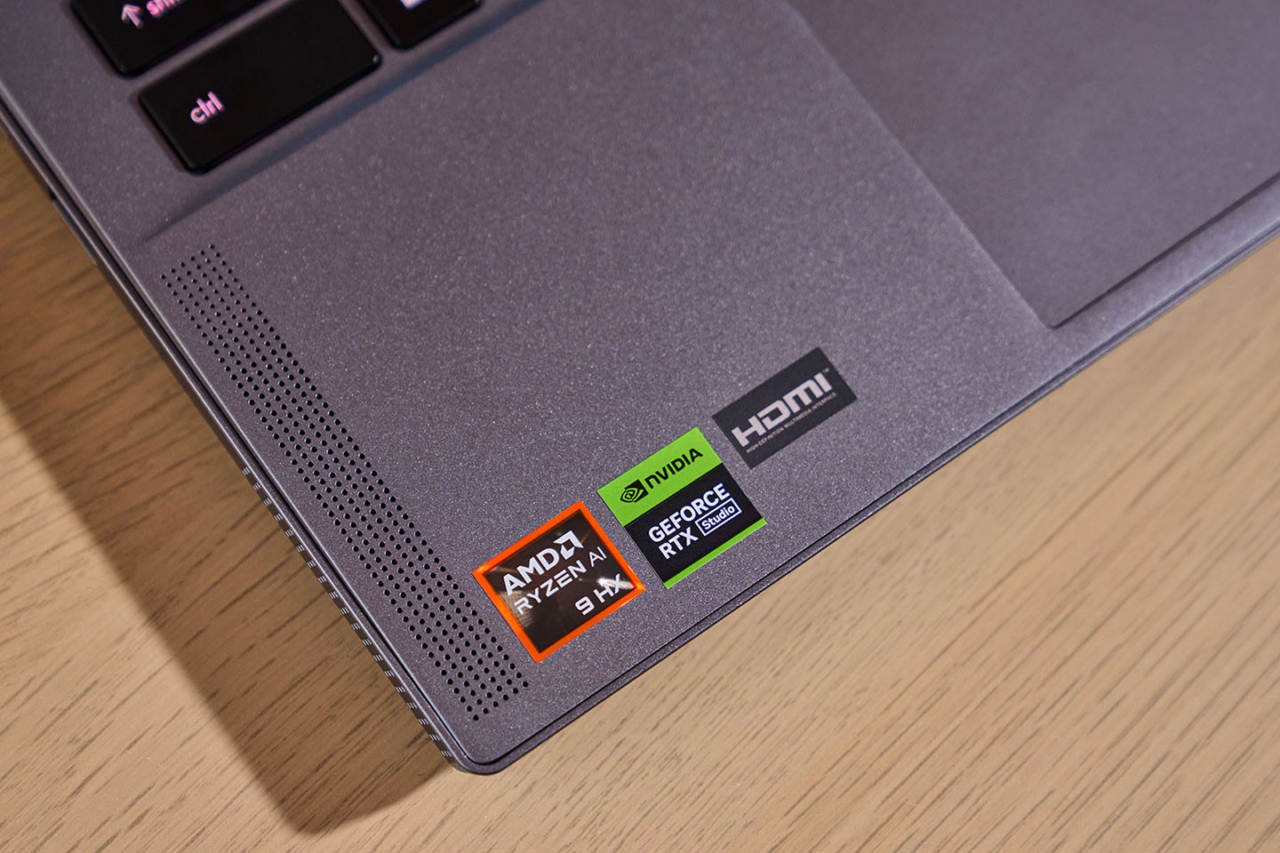 機身 C 面左下角有 AMD Ryzen AI 9 HX 與 NVIDIA GeForce RTX Studio 的標章貼紙。