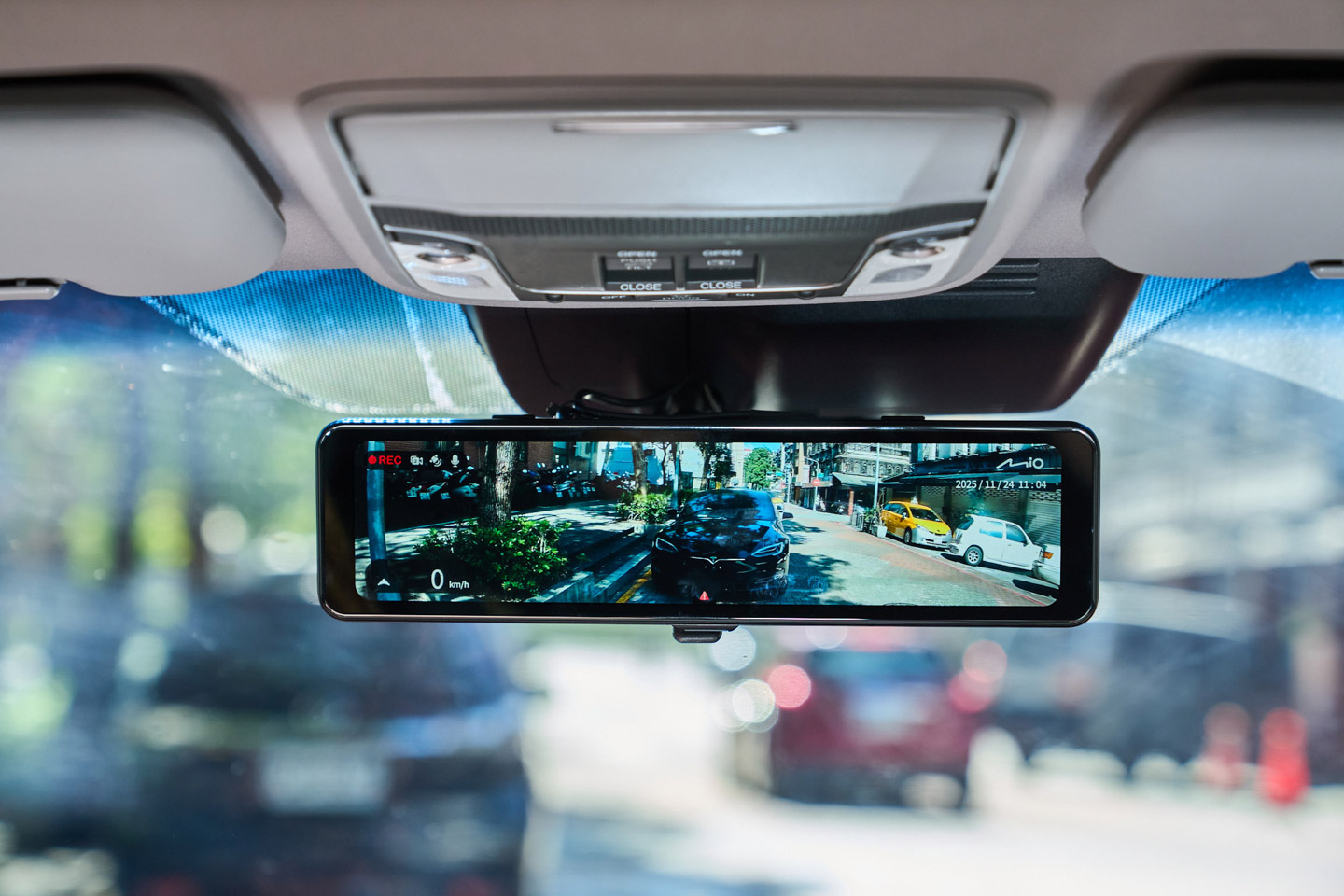 安裝完成後,只要車輛發動,MiVue R890WD 的螢幕就會自動亮起並顯示後鏡頭的即時畫面,畫面左上角會顯示錄影狀態,左下方則同步顯示車速資訊,右上角則是 Mio Logo 以及日期與時間。整體介面設計乾淨簡單,資訊完整但不會讓人感覺凌亂。