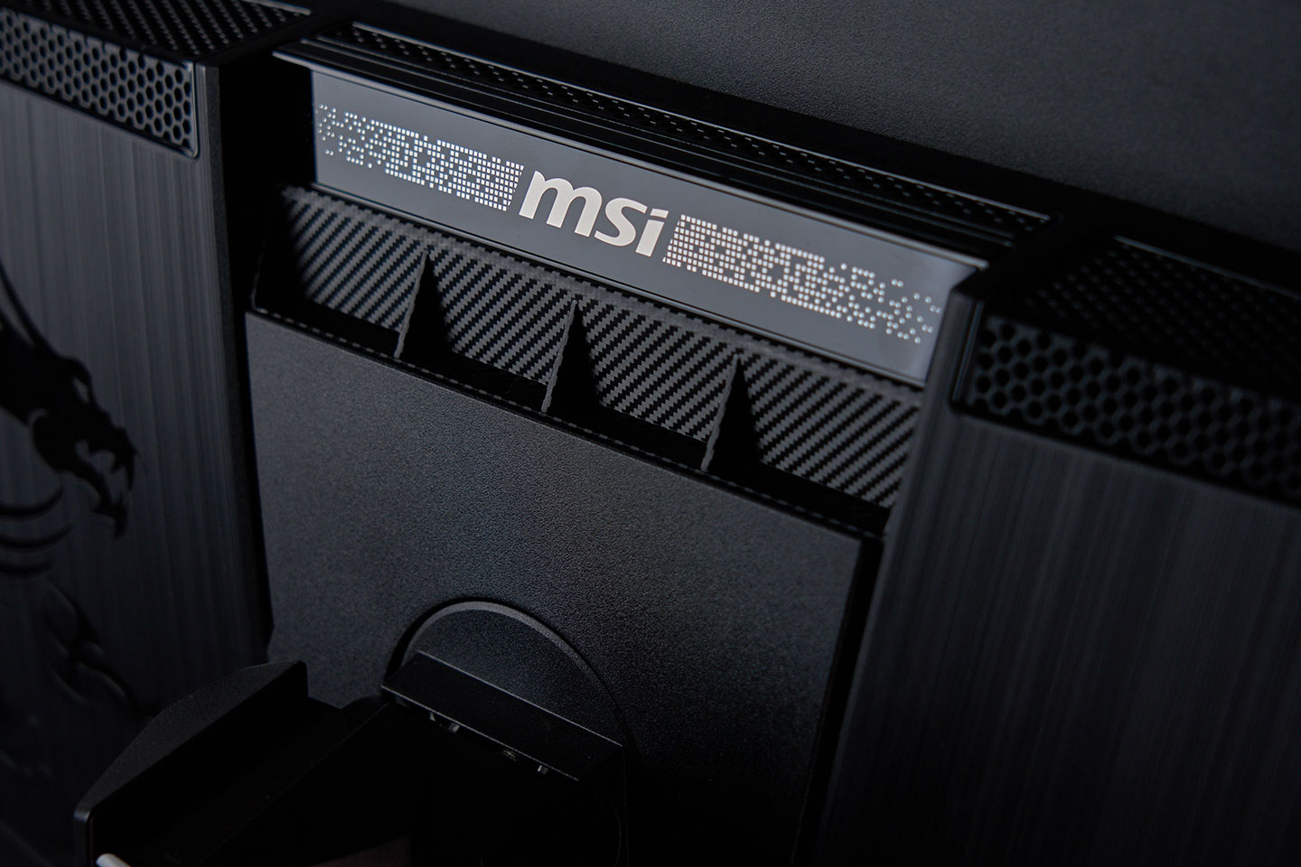 顯示器後側飾條上配置 MSI 的 Logo 並搭配點格狀紋理，為視覺增添些許層次感。