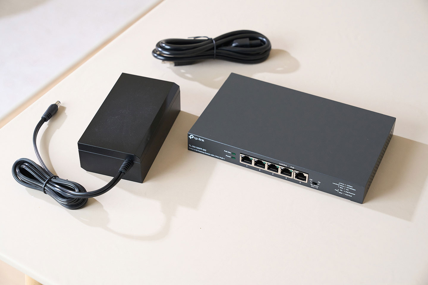 盒內的交換器本體、供電器與電源線。